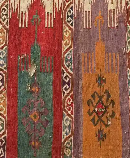 Two niche panels of a flatweave side by side, one red and green, one violet and orange, each with a lozenge at its centre