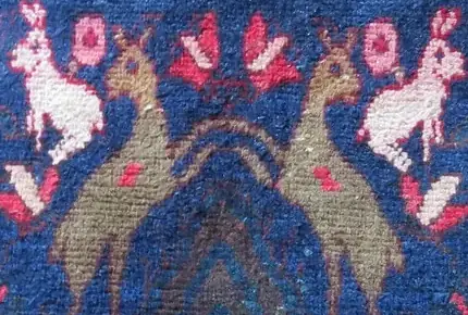 A close view of the pile: two deer face to face, every knot visible as a small tuft of wool